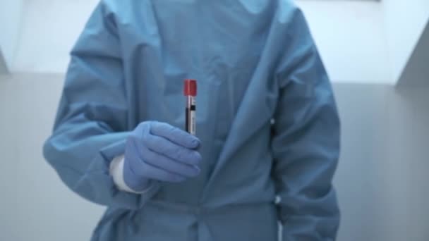 Mikrobiológus, orvosi dolgozó kéz kék kesztyűvel, vérvizsgálati eredményekkel — Stock videók