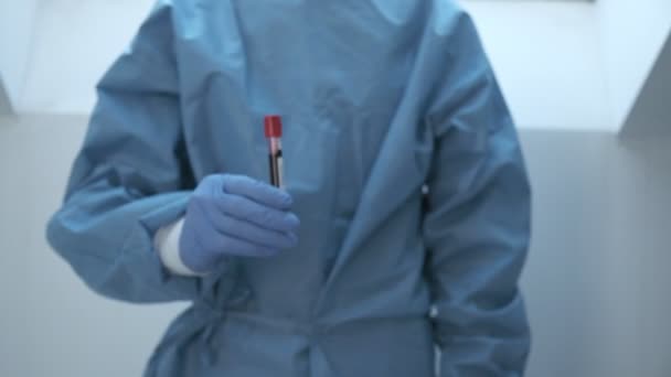 Microbiologo, mano operatore medico con guanti blu che mostrano il risultato degli esami del sangue — Video Stock