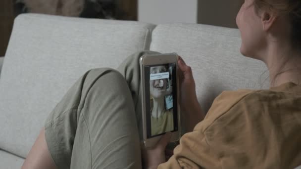 Mujer teniendo videocall en el teléfono inteligente. chica haciendo chat en línea en el teléfono en casa — Vídeo de stock