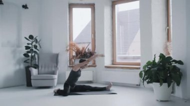 Kameraman spor giysili formda kızı yerde esnetirken çekiyor. vlog sahne arkasında