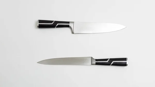 Duas facas de cozinha afiadas com alças pretas. fundo branco flatlay. Vista superior — Fotografia de Stock