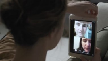 Akıllı telefondan video görüşmesi yapan bir kadın. Kız evde telefonla sohbet ediyor.