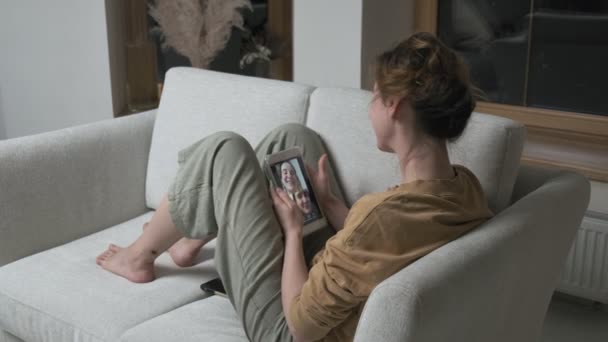 Žena má videokall na smartphonu. dívka dělat chat on-line na telefonu doma — Stock video