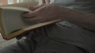 Sayfaları yapraklandıran genç adamların ellerine yakın çekim. Karantina sırasında etkinlik ve hobi