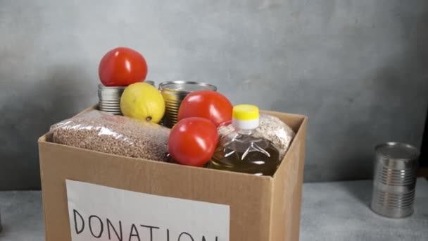 Κουτί δωρεών στο τραπέζι γεμάτο με τρόφιμα παντοπωλείου: λαχανικά, λάδι, δημητριακά, φρούτα — Αρχείο Βίντεο