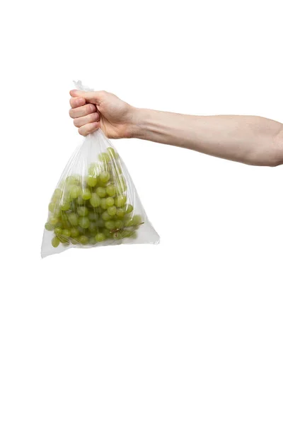 Bolsa de polietileno en mano aislada en blanco. hombre sosteniendo paquete de uva fresca —  Fotos de Stock