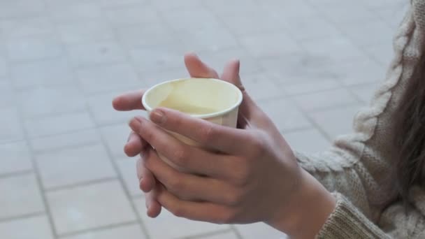 Mãos femininas segurando xícara de papel com café. menina segura caneca, close-up, sem rosto — Vídeo de Stock