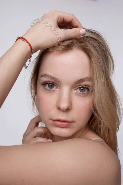 Vrij blank meisje met naakte schouders kijkend naar de camera. portret, close up — Stockfoto