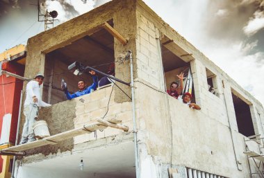 Holbox, Quintana Roo, Mexico / - Jun 2017 The Importance of Happiness in the Workplace Concept Happy Mexican Mason Workers on a construction