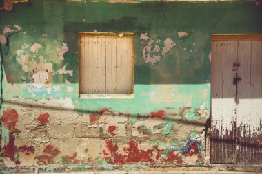 Evin duvarında paslı, çatlak, yıpranmış boya var. 