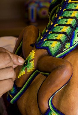 Close up of Mexican Huichol Art, Colorful decoration using symbols and designs which date back centuries, products are 