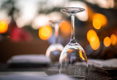 Zarif bir restoranda, boş bir masada şarap kadehlerini ters çevirdim.. 