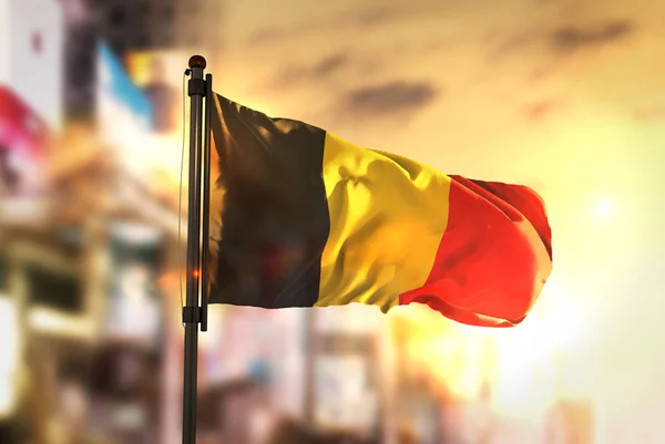 Bandera de Bélgica contra ciudad borrosa fondo al amanecer Backligh — Foto de Stock
