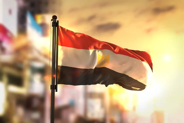 Vlajka Egypta proti City rozmazané pozadí při východu slunce podsvícení — Stock fotografie
