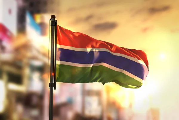 Die Gambia-Flagge vor verschwommenem Hintergrund bei Sonnenaufgang — Stockfoto