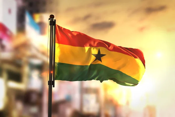 Ghana Flag Against City Blurred Background At Sunrise Backlight — Stock Photo, Image