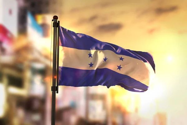 Flaga Hondurasu przeciwko City niewyraźne tło na wschód Backlig — Zdjęcie stockowe