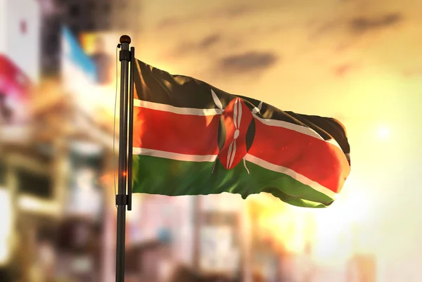 Bandeira do Quênia contra o fundo borrado da cidade ao nascer do sol — Fotografia de Stock