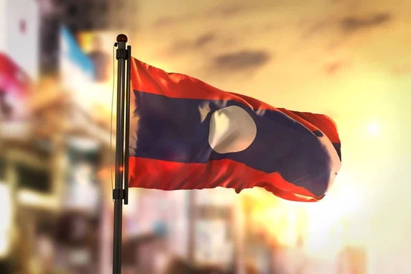 Laos Flagge vor verschwommenem Hintergrund bei Sonnenaufgang — Stockfoto