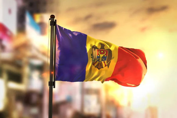 Bandeira da Moldávia contra a cidade desfocada fundo ao nascer do sol Backligh — Fotografia de Stock