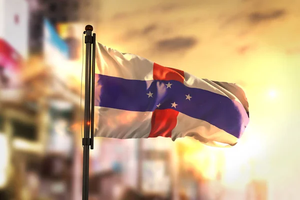 Netherlands Antilles Flag Against City Blurred Background At Sun — Stock Photo, Image