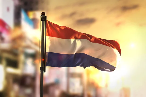 Netherlands Flag Against City Blurred Background At Sunrise Back — Stock Photo, Image