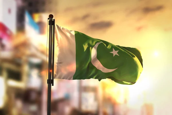 Vlajka Pákistánu proti City rozmazané pozadí v Sunrise Backlig — Stock fotografie