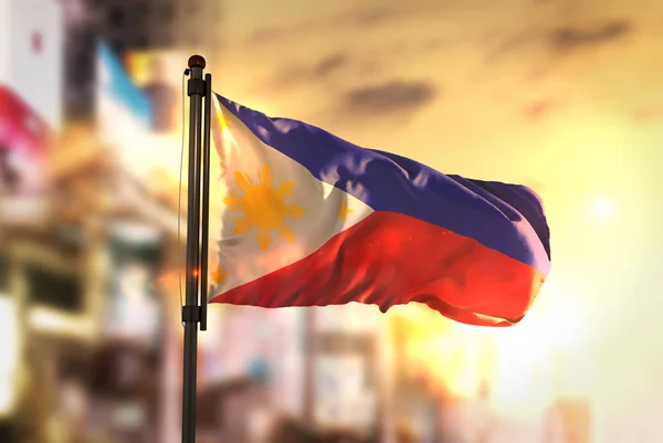 Bandeira das Filipinas contra a cidade Desfocada ao nascer do sol — Fotografia de Stock