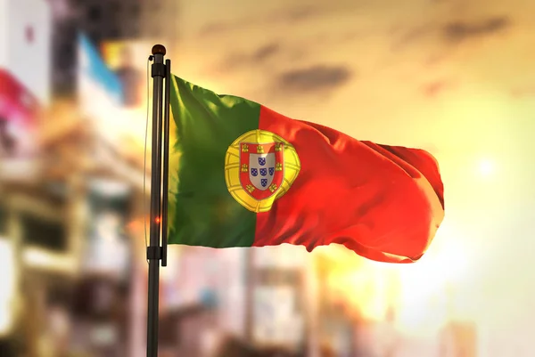 Portugal vlag tegen stad wazig achtergrond bij zonsopgang Backlig — Stockfoto