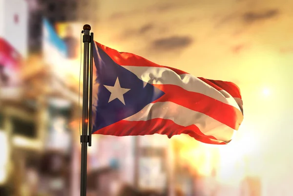 Bandera de Puerto Rico contra fondo borroso de la ciudad al amanecer — Foto de Stock