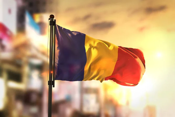 市に対してルーマニアの国旗日の出 Backligh で背景がぼやけ — ストック写真