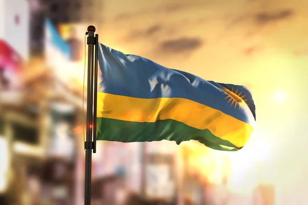 Rwanda Flag Against City Blurred Background At Sunrise Backlight — Stock Photo, Image