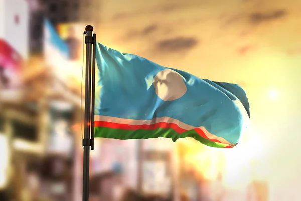 Sakha Republik Flagge gegen Stadt verschwommenen Hintergrund bei Sonnenaufgang b — Stockfoto