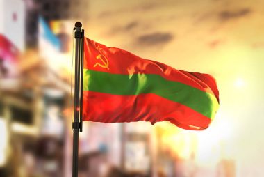Transnistria Flag Against City Blurred Background At Sunrise Bac clipart