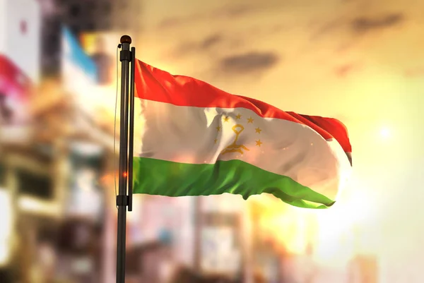 Tajikistan Flag Against City Blurred Background At Sunrise Backl — Stock Photo, Image