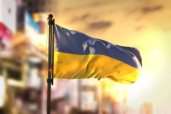 Bandera de Ucrania contra ciudad borrosa fondo al amanecer Backligh —  Fotos de Stock