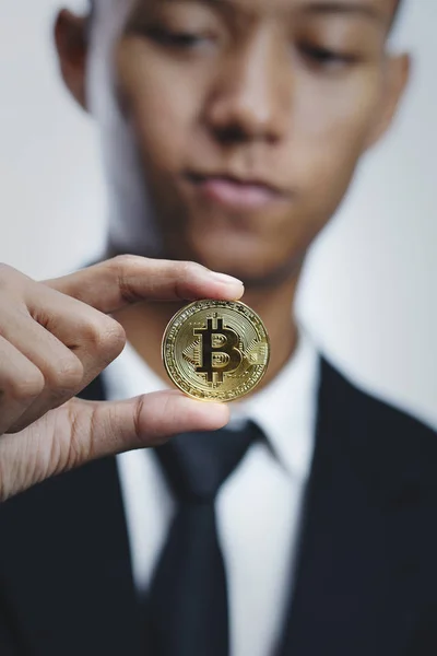 Empresário asiático segurando Bitcoin fundo brilhante — Fotografia de Stock