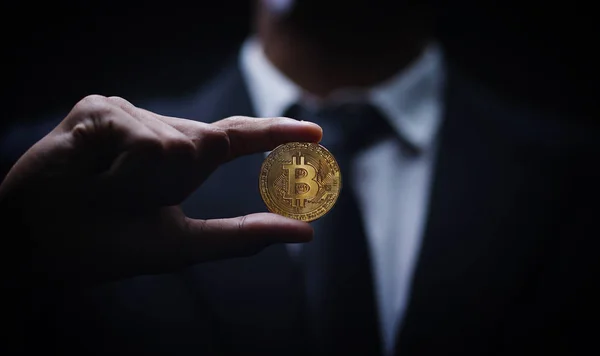 Empresário asiático segurando Bitcoin fundo escuro — Fotografia de Stock