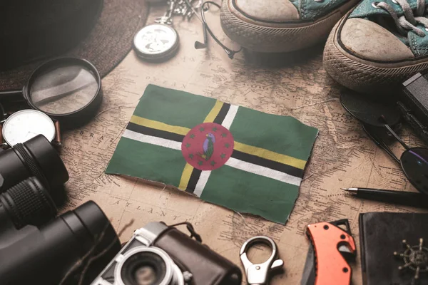 Dominica Bandiera tra gli accessori del viaggiatore sulla vecchia mappa Vintage . — Foto Stock