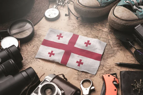 Georgia vlag tussen accessoires van reizigers op oude vintage kaart. — Stockfoto
