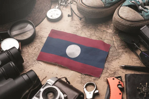 Bandera de Laos entre los accesorios del viajero en el antiguo mapa vintage. Tou. — Foto de Stock