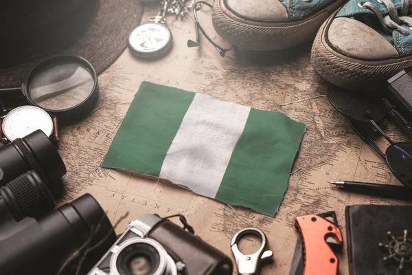 Nigeria Flag Between Traveler's Accessories on Old Vintage Map. — Stock Photo, Image