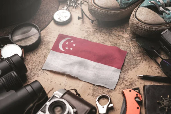 Сингапурский флаг между аксессуарами путешественника на старинной карте — стоковое фото