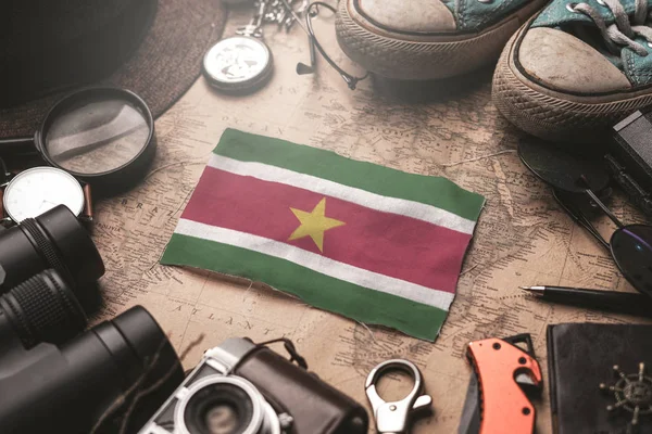 Suriname Flag Between Traveler's Accessories on Old Vintage Map. — Stock Photo, Image