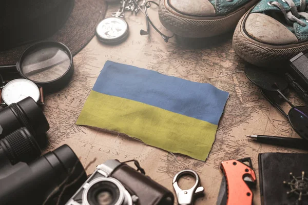 Ukrainische Flagge zwischen Reiseaccessoires auf alter Landkarte. — Stockfoto