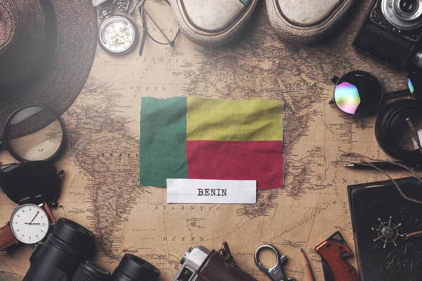 贝宁在古旧地图上的旅行者配件之间悬挂国旗。 Ov — 图库照片