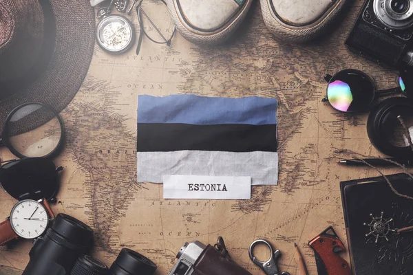 Estland vlag tussen accessoires van reizigers op oude vintage kaart. — Stockfoto