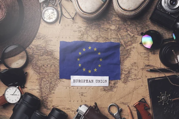Europese vlag tussen accessoires van reizigers op oude vintage kaart. — Stockfoto