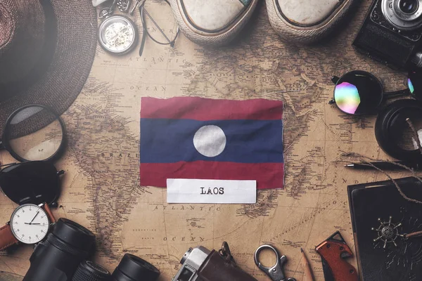 Laos vlag tussen accessoires van reizigers op oude vintage kaart. Ove — Stockfoto