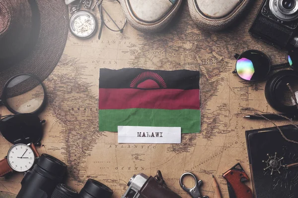 Bandiera del Malawi tra gli accessori del viaggiatore sulla vecchia mappa vintage. O — Foto Stock